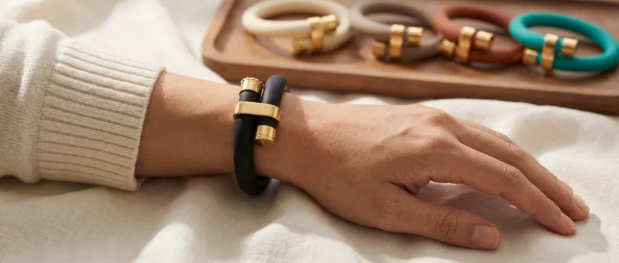 wristraw Signature worn on the wrist, with all 5 colorways on a wood tray in the background